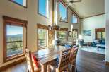 This stunning property boasts a rustic charm with its wooden dining table and chairs, perfect for family gatherings.
