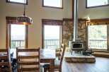 Experience the charm of this stunning property, featuring a cozy dining area with a rustic wooden table and chairs.