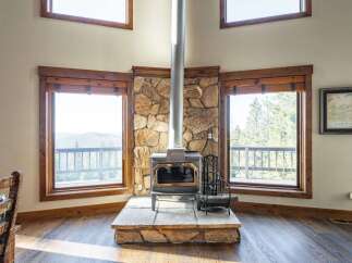This stunning property boasts a cozy living space centered around a beautiful stone fireplace, perfect for those chilly evenings.