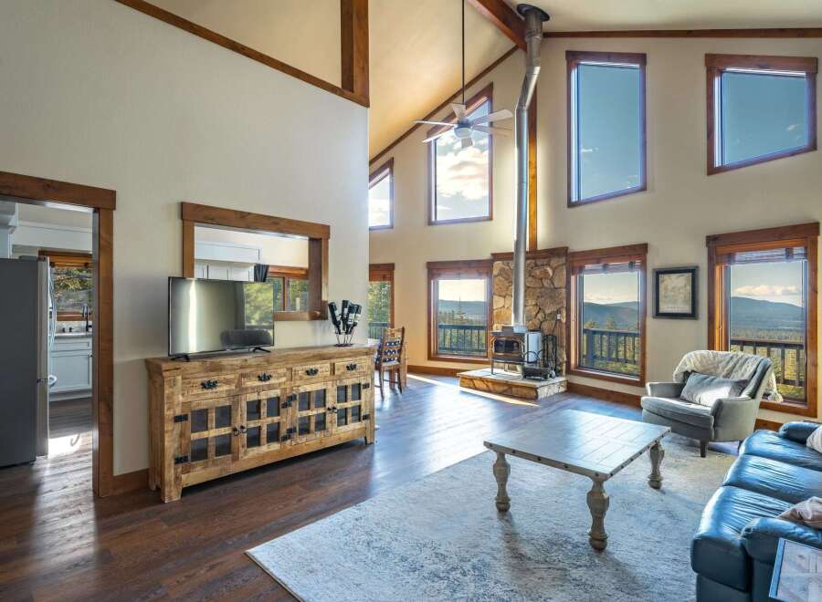 Experience luxury living in this stunning property, featuring a spacious living area with high ceilings and large windows that offer breathtaking views.