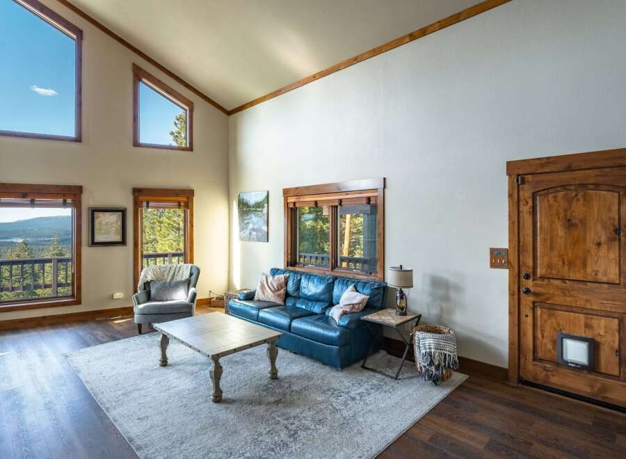 Experience luxury living in this stunning property, featuring a spacious living room with high ceilings and large windows that offer breathtaking views.