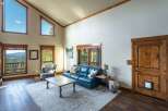 Experience luxury living in this stunning property, featuring a spacious living room with high ceilings and large windows that offer breathtaking views.