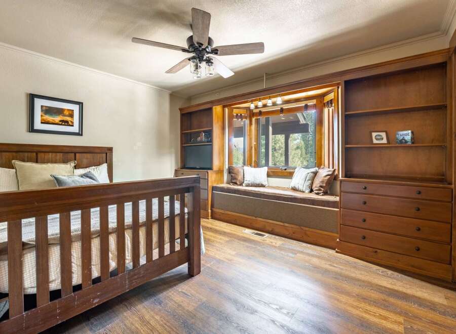 Step into this inviting bedroom, featuring a cozy window seat and ample storage.