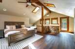 This stunning bedroom boasts a unique architectural design with exposed wooden beams and a vaulted ceiling, creating a cozy and inviting atmosphere.