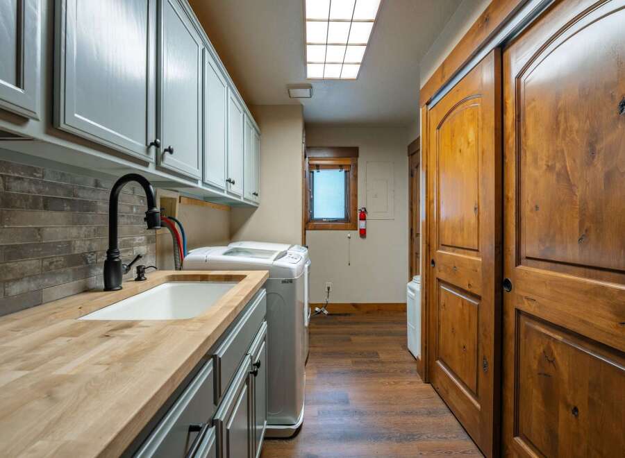 This stunning laundry room boasts a sleek design with ample storage and modern amenities.