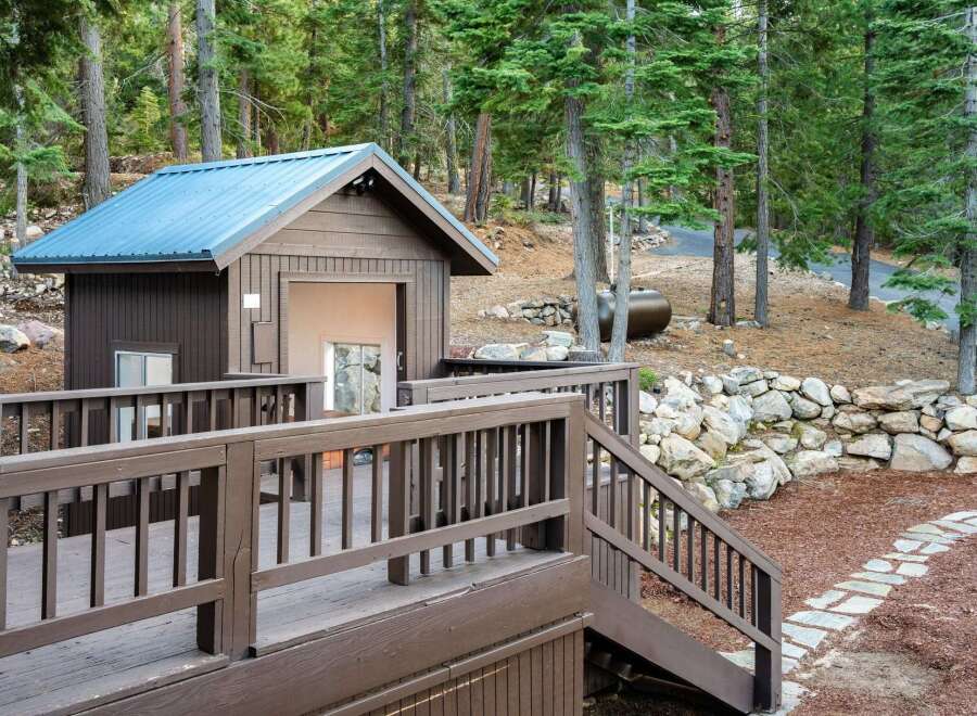 Nestled in a serene wooded setting, this property boasts a charming cabin with a distinctive blue roof.