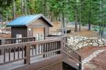 Nestled in a serene wooded setting, this property boasts a charming cabin with a distinctive blue roof.