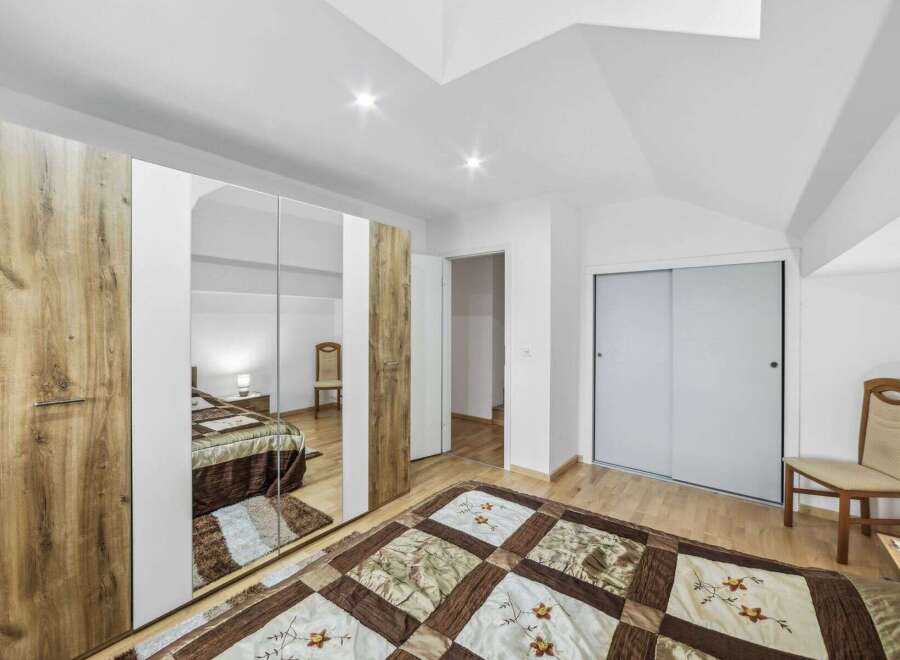 Step into this inviting bedroom, featuring a spacious wardrobe with mirrored doors that reflect the room's natural light.