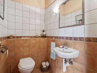 Step into this charming bathroom, featuring a classic design with tiled walls and a cozy atmosphere.