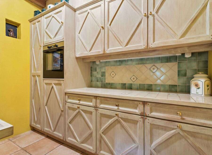 This charming kitchen boasts custom cabinetry and a built-in oven, perfect for culinary enthusiasts.