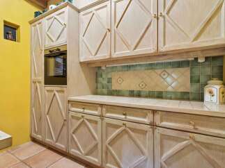 This charming kitchen boasts custom cabinetry and a built-in oven, perfect for culinary enthusiasts.