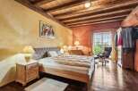 This charming bedroom boasts a rustic aesthetic with exposed wooden beams and warm, inviting colors.