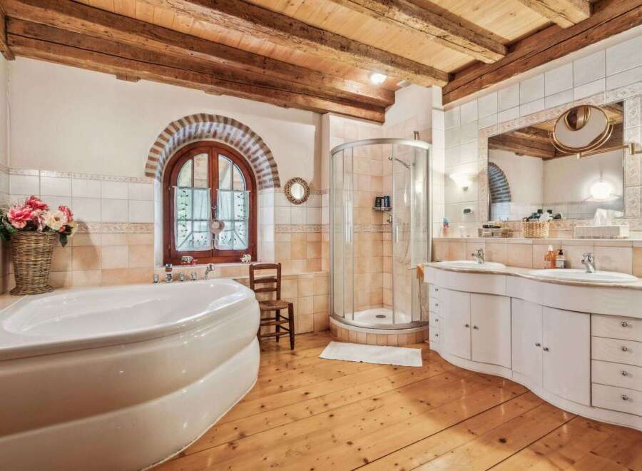 This luxurious bathroom boasts a rustic charm with its wooden beams and flooring.