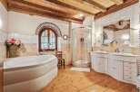 This luxurious bathroom boasts a rustic charm with its wooden beams and flooring.