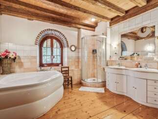 This luxurious bathroom boasts a rustic charm with its wooden beams and flooring.