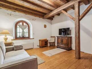 Discover the charm of this rustic living space, featuring exposed wooden beams and a cozy ambiance.