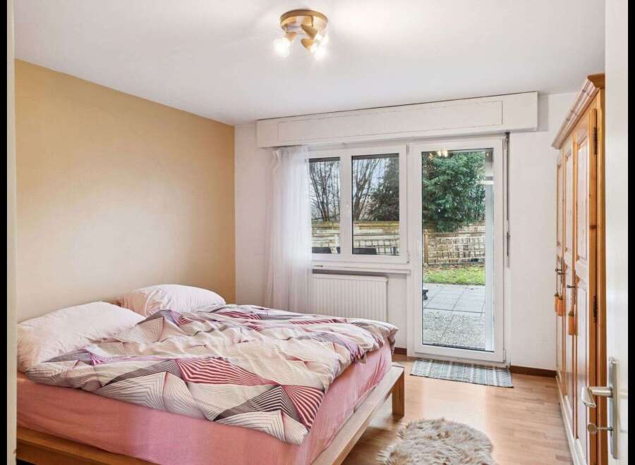 This cozy bedroom features a comfortable bed with stylish bedding and a soft rug.