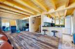 Experience the charm of this stunning property, featuring a rustic wooden dining table and a cozy living area.