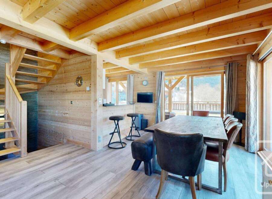 This stunning property boasts a warm and inviting interior with exposed wooden beams and paneling, creating a cozy atmosphere.