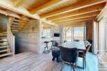 This stunning property boasts a warm and inviting interior with exposed wooden beams and paneling, creating a cozy atmosphere.