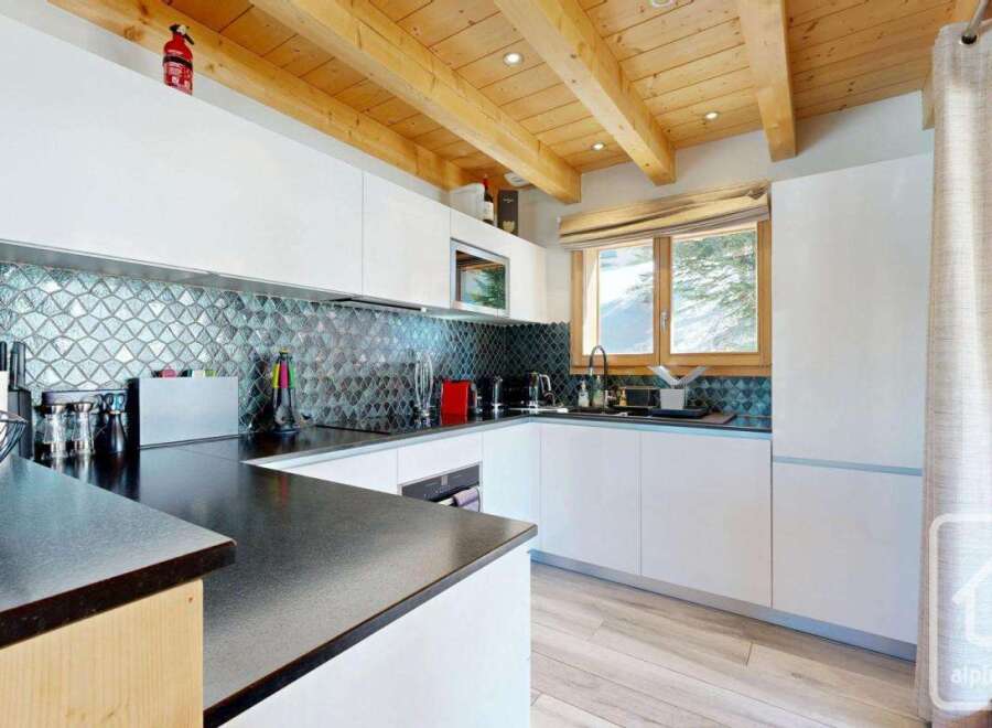 This stunning kitchen boasts modern design with sleek white cabinetry and a striking backsplash.