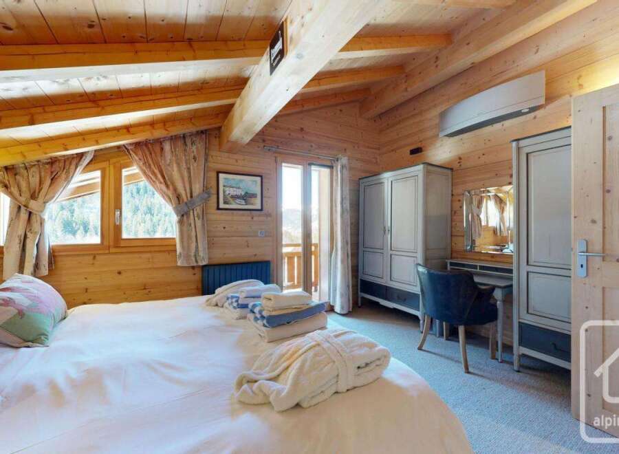 Experience the charm of this cozy bedroom, featuring a warm wooden interior and a comfortable bed.
