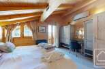 Experience the charm of this cozy bedroom, featuring a warm wooden interior and a comfortable bed.