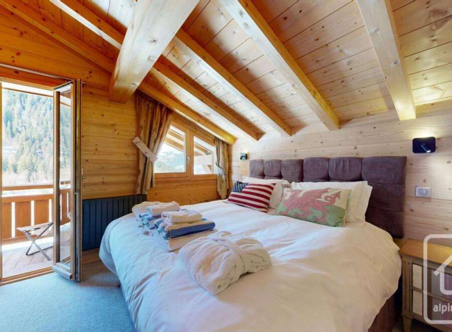 Experience the charm of this stunning bedroom, featuring a cozy ambiance with wooden accents and a comfortable bed.