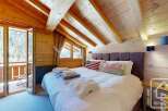 Experience the charm of this stunning bedroom, featuring a cozy ambiance with wooden accents and a comfortable bed.