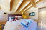 Experience the charm of this cozy bedroom featuring a rustic wooden ceiling and walls, creating a warm and inviting atmosphere.