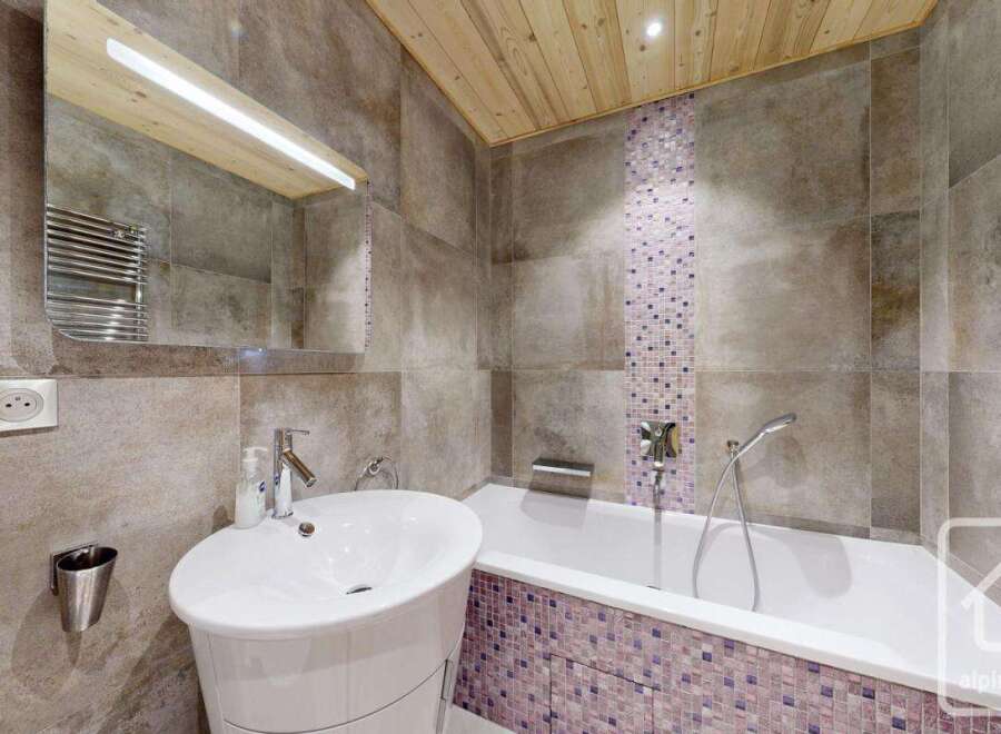 This modern bathroom features a sleek design with a combination of wood and tile.