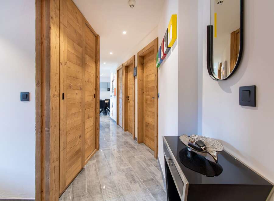 Step into a beautifully designed hallway with stunning wooden doors and a modern aesthetic.
