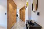 Step into a beautifully designed hallway with stunning wooden doors and a modern aesthetic.