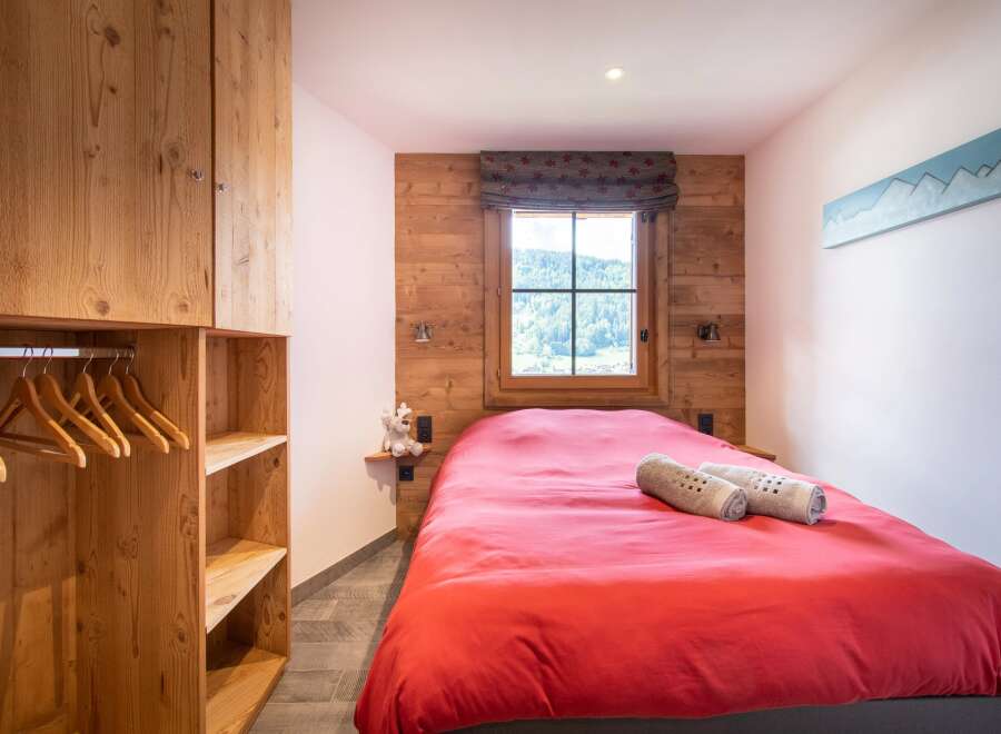 This cozy bedroom features a warm wooden interior, creating a rustic and inviting atmosphere.