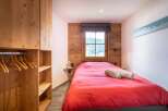 This cozy bedroom features a warm wooden interior, creating a rustic and inviting atmosphere.