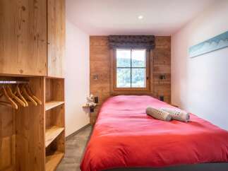 This cozy bedroom features a warm wooden interior, creating a rustic and inviting atmosphere.