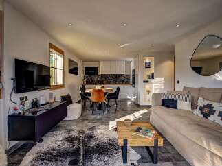 Experience modern living in this open-concept space featuring a sleek kitchen with white cabinetry and a striking black backsplash.