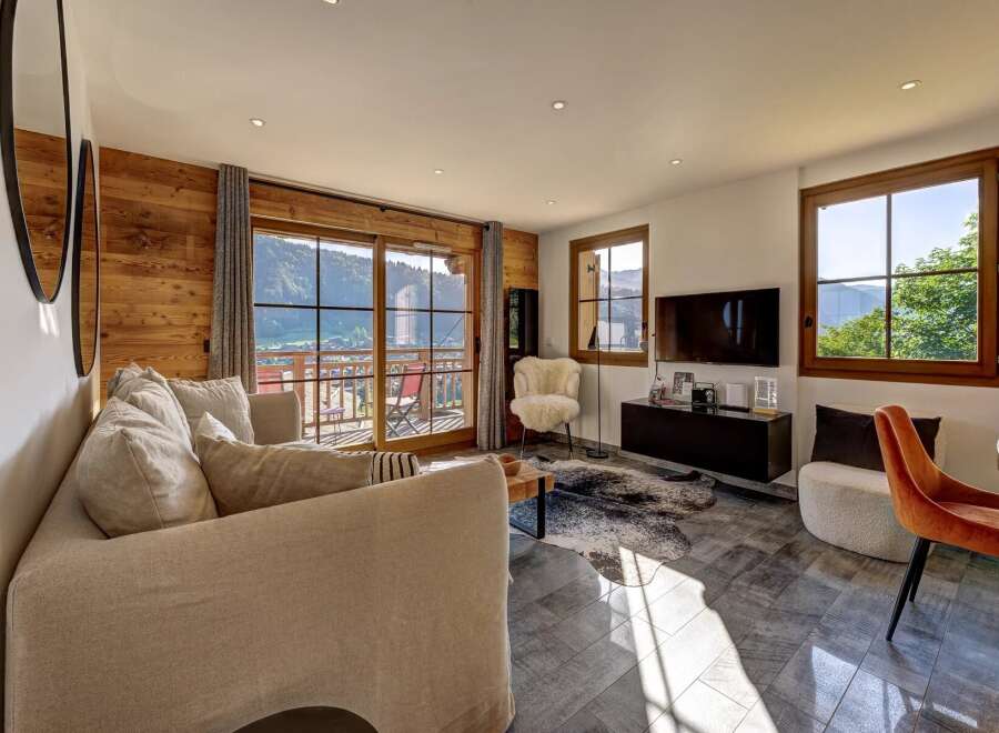 Experience breathtaking mountain views from this stunning living room, featuring a cozy sectional sofa and a modern entertainment center.