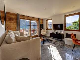 Experience breathtaking mountain views from this stunning living room, featuring a cozy sectional sofa and a modern entertainment center.