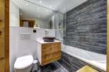 Experience modern mountain living in this beautifully appointed bathroom, featuring a sleek floating vanity with natural wood drawers and a striking stone vessel sink.