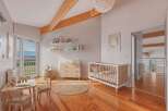 This charming nursery features a bright and airy design with natural wood flooring and exposed beams.