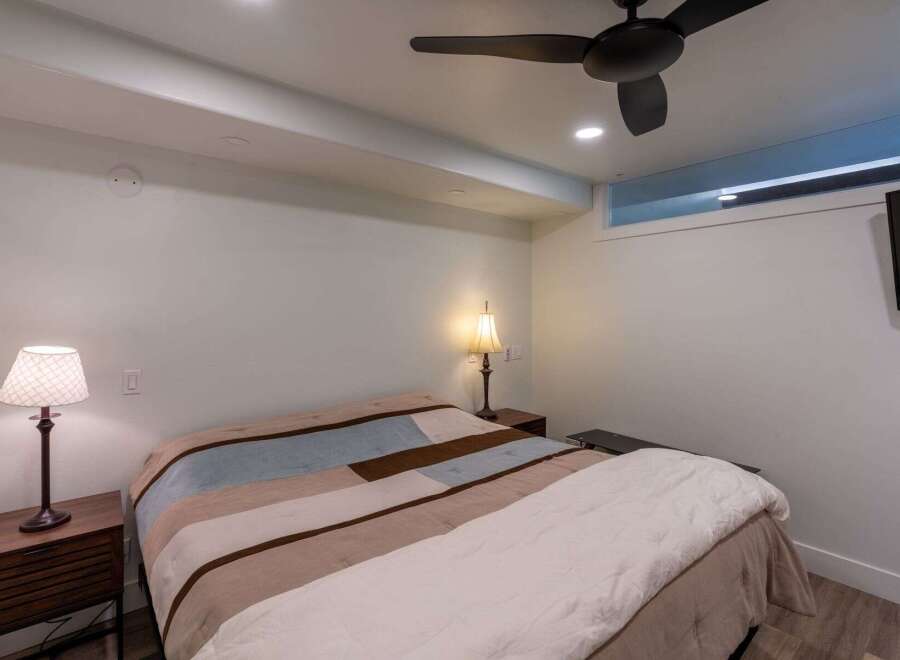 This cozy bedroom features a comfortable bed with a stylish quilt, perfect for a relaxing night's sleep.