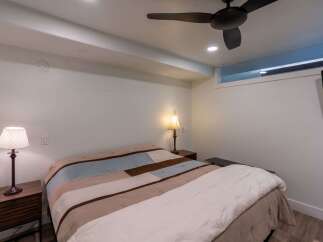 This cozy bedroom features a comfortable bed with a stylish quilt, perfect for a relaxing night's sleep.