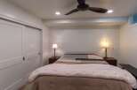 This cozy bedroom features a comfortable bed with a stylish quilt and bedside lamps, creating a warm and inviting atmosphere.
