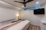 Discover the comfort of this inviting bedroom, featuring a stylish ceiling fan and a modern wall-mounted TV.