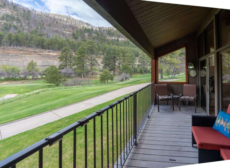 Enjoy breathtaking views from this stunning property! This home features a spacious deck overlooking a lush green golf course and majestic mountains.