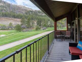 Enjoy breathtaking views from this stunning property! This home features a spacious deck overlooking a lush green golf course and majestic mountains.