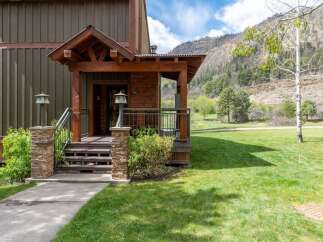 This stunning property boasts a charming exterior with a welcoming porch and a beautifully landscaped yard.