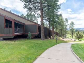 Discover a stunning property with a unique architectural design, nestled amidst lush greenery and mature trees.