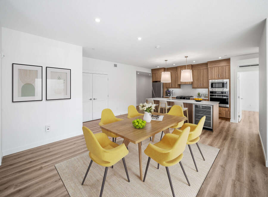 This stunning property features a modern dining area with a wooden table and stylish yellow chairs.